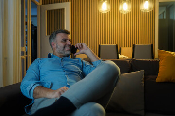 Fototapeta premium Portrait of modern mixed race man speaking by phone in cozy interior, copy space