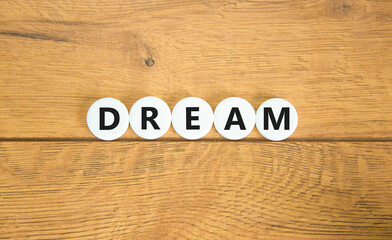 Dream symbol. Concept word Dream on beautiful white pills circles. Beautiful wooden table wooden background. Business lifestyle dream concept. Copy space.