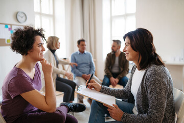 Woman talking with psychologist during group therapy.