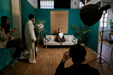 Professional photographer taking fashion shot during studio photoshoot