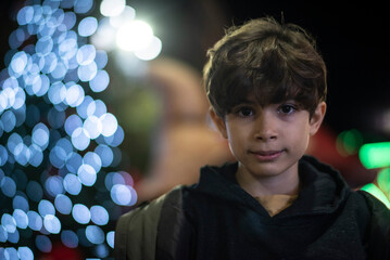 Portrait of a Ten-Year-Old Child Beside Christmas Lights at Night