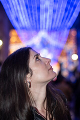 Informal Portrait of a Woman Looking at Christmas Lights in a European City on a Winter Night