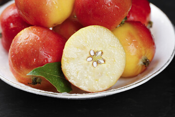 Fresh Red and Yellow Apples with Sliced Half on White Plate
