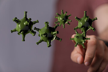 3D rendered illustration of green virus particles floating in space and being touched by a finger,...