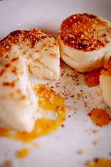 Close-up of cottage cheese pancakes showing soft creamy texture with fruit sauce. Warm tones, shallow depth of field and cozy homemade dessert aesthetic.