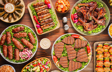 Arabic Cuisine; A variety of grilled meat dishes such as grilled fillet, ribs, kofta, tarb and shish tawook. Served with delicious side dishes. Top view with close up.