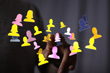 Hand pointing at a digital network of abstract people in a collaborative teamwork or communication context. Symbolizing connection, communicatio