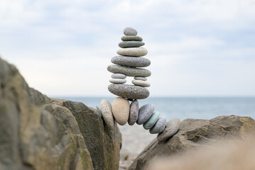 Small stone cairns stacked on the beach, creating pyramid-like shapes and trail markers. Highlights...