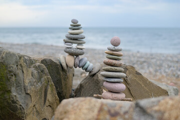 Small stone cairns stacked on the beach, creating pyramid-like shapes and trail markers. Highlights...