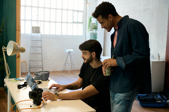 Creative men collaborating on computer in office - Powered by Adobe