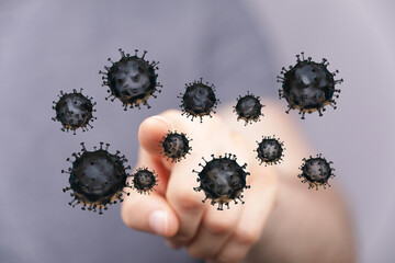 Hand pointing at a collection of coronavirus particles, symbolizing concepts of health, disease, and global pa
