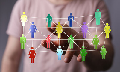 Hand interacting with a network of digital human figures representing social connections, teamwork, and global communication.