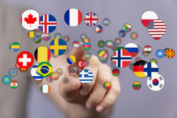 A hand pointing at various country flags representing international connections, global teamwork, and multicultural understanding. Ideal for con