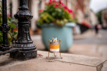 Decorative ashtray with cigarettes on urban pavement