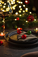 Christmas Table Setting with Tree-Shaped Napkin and Tealight Candles against Christmas lights