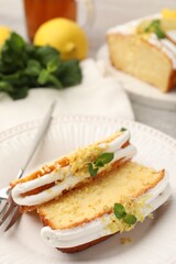Delicious lemon cake with glaze, fresh fruit slices and mint served on table, closeup