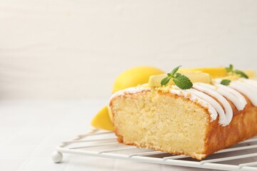 Delicious lemon cake with glaze, fresh fruit slices and mint on light table, closeup. Space for text