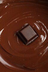 Tasty melted chocolate and piece as background, closeup
