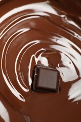Tasty melted chocolate and piece as background, closeup