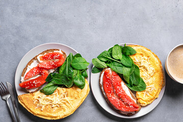 Healthy breakfast for two. Omelette, sandwich with salmon, spinach.