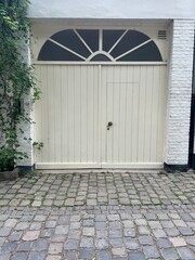 A white garage door on a white building