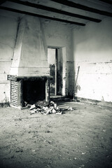 Black and white image of a chimney in a ruined house.