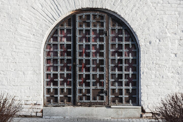 Old metal doors in a white wall.