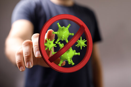 Concept image featuring a hand pointing at a red no-entry sign with a virus, symbolizing prevention and protec