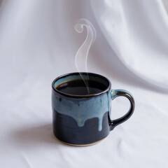 Steaming hot coffee in a unique blue ceramic mug