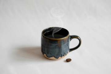 Steaming hot coffee in a unique blue ceramic mug