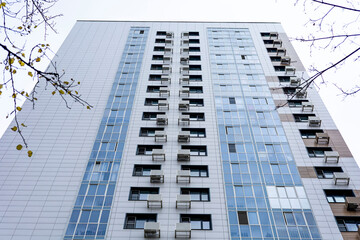 Obraz premium Modern architecture of an urban apartment building from the bottom up. High-rise building.