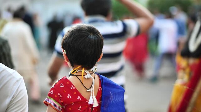 Child observing Ganesha festival procession in India, traditional cultural celebration