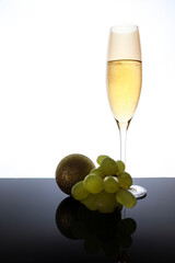 Champagne on classic champagne glass next to bunch of grapes