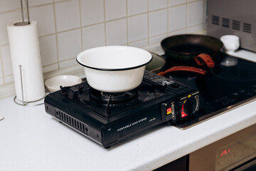 Portable camping gas stove. Blackout in the city. House without electricity. Heating food on gas.