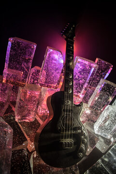 Music Concept: Guitar Miniature on a Dark Background with Vivid Light, Smoke, and Fire Effects. Golden electro guitar under a Dramatic Spotlight.