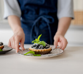 Girl Holding Blueberry Dessert At Home In The Kitchen Close-Up