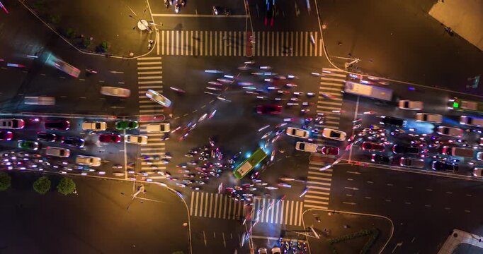 Top-down drone timelapse of busy urban intersection with cars, motorbikes, and public buses in Ho Chi Minh City (Saigon), Vietnam. Dynamic traffic flow and fast-paced metropolitan life in Asia. 