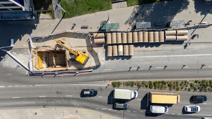 Aerial view of construction site with excavator and pipes