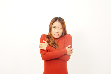 Uncomfortable young woman wrapping her arms around herself, shivering from the cold or feeling frightened and nervous.