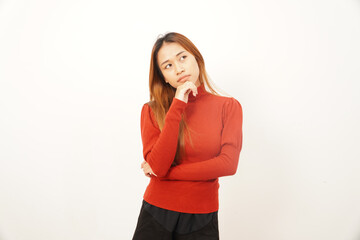 Pensive young woman thinking deeply with her hand on her chin, looking upwards to find an idea or solution.