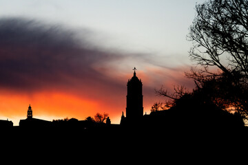 Montilla, spain city skyline forming a silhouette under a vibrant orange and purple dramatic sunset sky