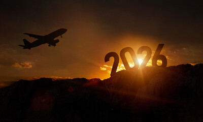 Silhouette of number 2026 on mountain, Happy New Year celebration shiny design. Plane in flight, travel background with plane flying in sunset sky