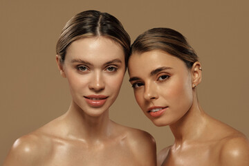 Two beautiful women with glowing skin and natural makeup in studio