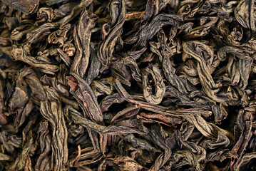 Macro close-up of dried tea leaves with rich brown and green tones. Natural texture, organic pattern, loose leaf tea background for food, beverage, wellness, and packaging design.