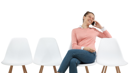 Happy young woman with glasses talking on phone laughing during conversation while sitting on chair in queue