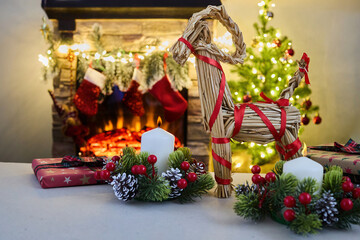 Fototapeta premium Julbock Christmas goat. A cozy Christmas setting with gifts, candles, a straw goat,