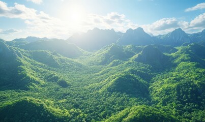 Fototapeta premium Scenic mountain range with lush green forests under a bright blue sky, sunlight illuminating the peaks and creating contrast
