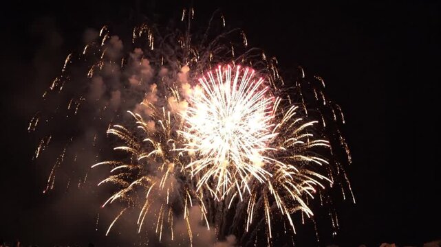 Bright explosions of festive fireworks illuminate the night sky with brilliant light displays