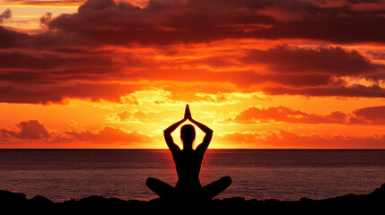 Sunset yoga instructor meditating on beach with calm ocean and vibrant sky