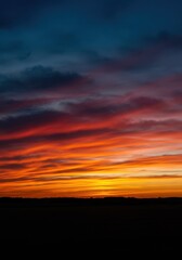 Obraz premium Intense, vibrant colors illuminate the horizon as dynamic, wispy clouds streak across the sky during a dramatic and inspiring magical sunset ,Sunset ,wispy ,sky